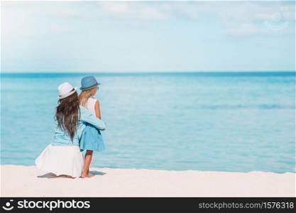 Mom with little daughter on the beach. Beautiful mother and daughter at the beach enjoying summer vacation.