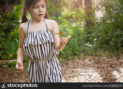 Monarch butterfly hovering over girls hand
