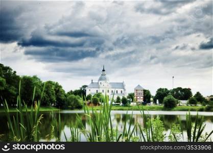monastery on calm lake at cloudy day