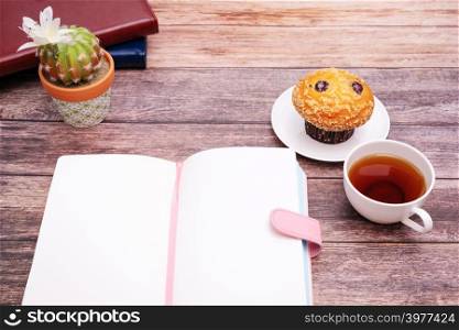 Monday Morning Concept, Hot tea and muffin cake on wooden workspace