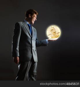 Monetary concept. Businessman holding huge cent coin in hand