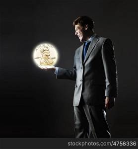 Monetary concept. Young businessman holding cent coin in palm