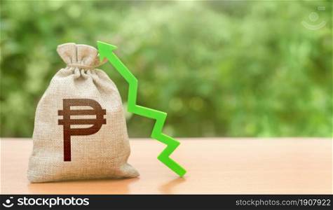 Money bag with philippine peso symbol and green up arrow. Economic recovery and growth. Increased profits. Attracting investment and capital. High bond yields. Trade surplus balance. Budget