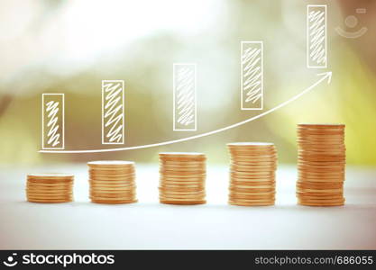 Money coins stack growing graph bank on nature background, saving finance and chart for growing success, business concept.