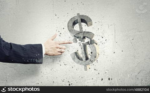 Money concept. Businessman breaking dollar stone symbol with finger touch