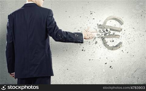 Money concept. Businessman breaking euro stone symbol with finger touch