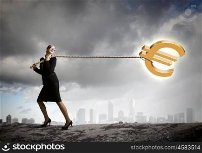 Money concept. Image of businesswoman pulling euro sign with rope
