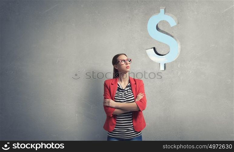 Money dollar concept. Thinking woman in red jacket looking up on dollar sign