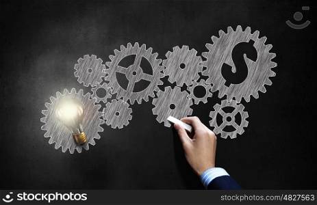 Money earning mechanism . Conceptual image of gears and cogwheels drawn with chalk