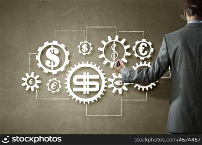 Money earning mechanisms. Back view of businessman standing with back and drawing gears mechanism