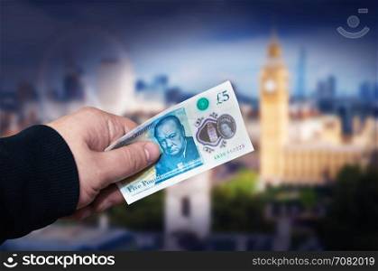 Money English five pound note in a man&rsquo;s hand concept. With clipping path.