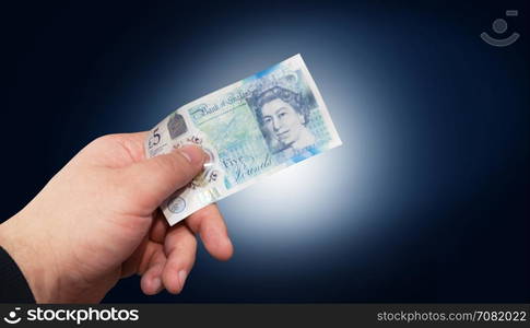 Money English five pound note in a man&rsquo;s hand concept. With clipping path.