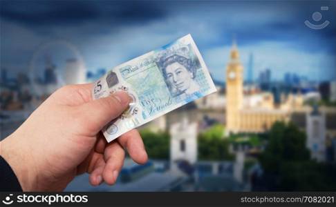 Money English five pound note in a man?s hand concept. With clipping path.