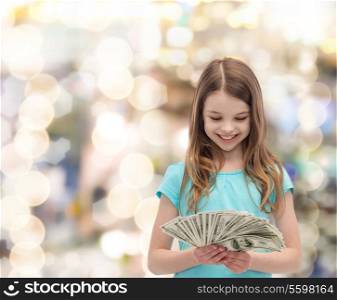 money, finances and people concept - smiling little girl looking at dollar cash money