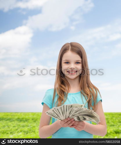 money, finances and people concept - smiling little girl with dollar cash money