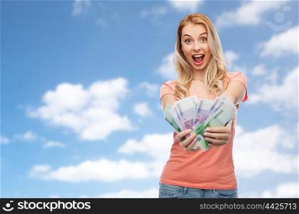 money, finances, investment, saving and people concept - happy young woman with euro cash money over blue sky and clouds background