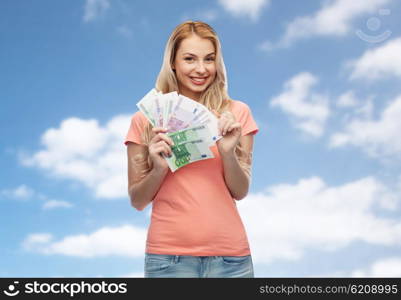 money, finances, investment, saving and people concept - happy young woman with euro cash money over blue sky and clouds background