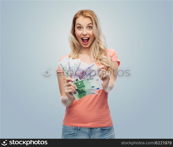 money, finances, investment, saving and people concept - happy young woman with euro cash money over gray background