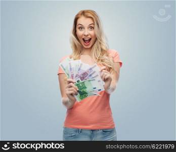 money, finances, investment, saving and people concept - happy young woman with euro cash money over gray background