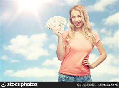 money, finances, investment, saving and people concept - happy young woman with dollar cash money over blue sky and clouds background. happy young woman with usa dollar cash money