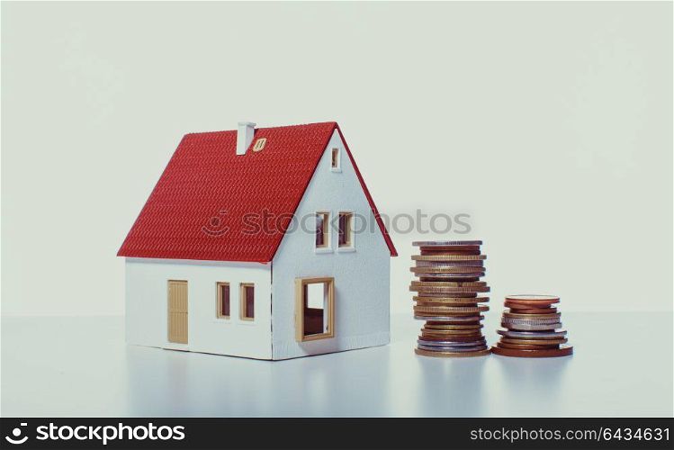 Money house from the coins on the white background. Concept for utility payments, subsidy. The money house