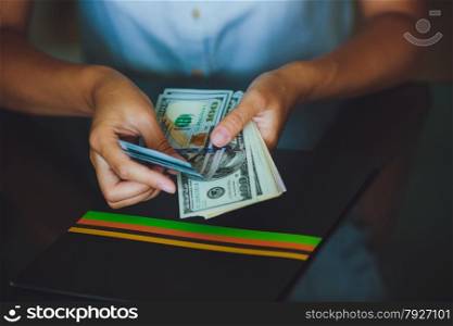 Money in human hands, women counting a lot of 100 dollars, with business folders , on a black background
