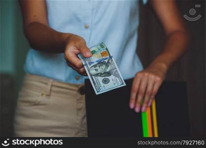 Money in human hands, women giving 100 dollars, with business folders , on a black background