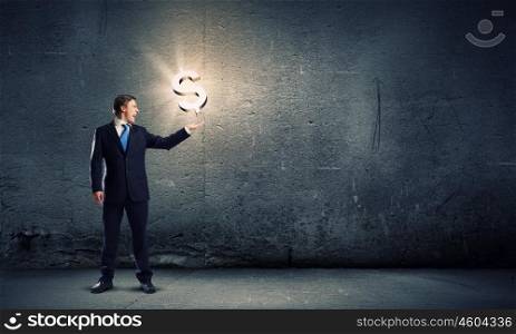 Money making. Businessman in suit holding dollar sign in palm
