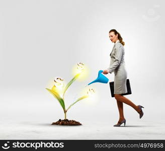 Money making concept. Image of businesswoman watering money tree with pot