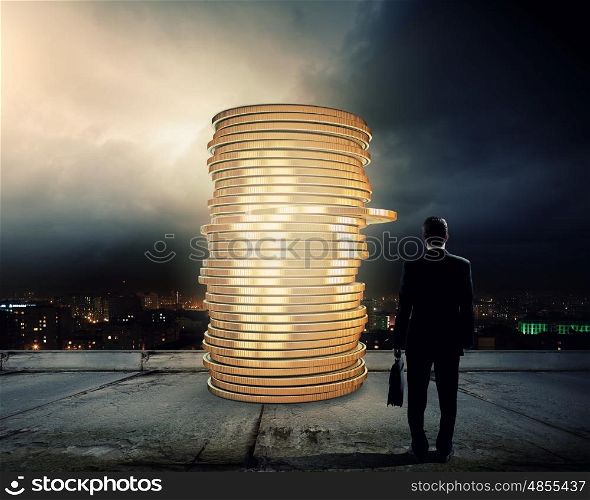 Money making. Rear view of businessman with suitcase looking at stack of coins