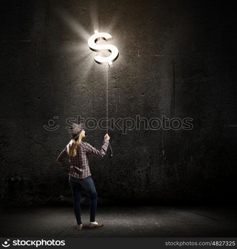 Money making. Young woman in casual holding balloon shaped like dollar