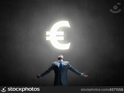Money power. Businessman with hands spread apart and euro sign above