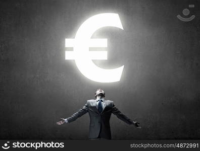 Money power. Businessman with hands spread apart and euro sign above