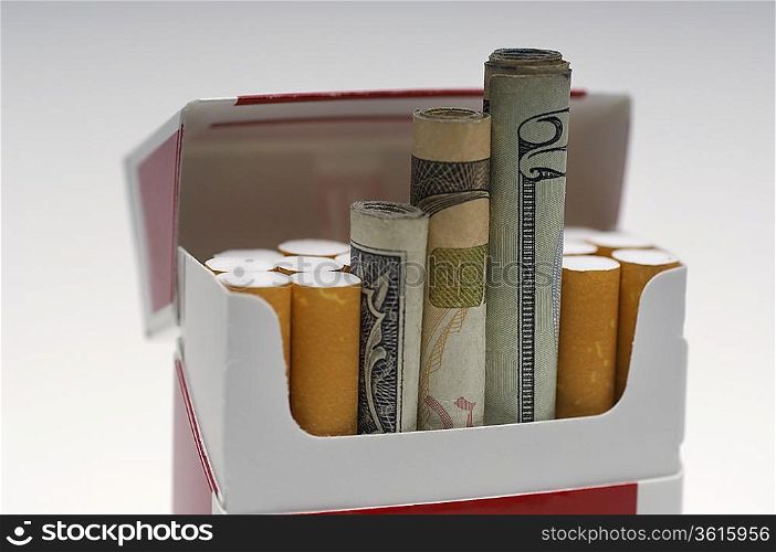 Money rolled up in cigarette box, close-up