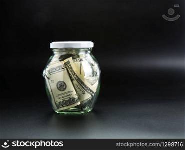 Money saving concept, glass jar full of dollars. Cash economy, home savings. Money saving concept, glass jar full of dollars