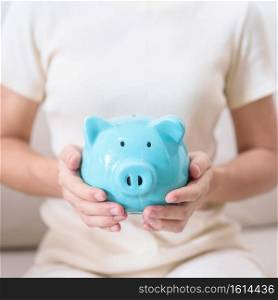 Money Saving for Future Plan, Retirement fund, Pension, Investment, Wealth Business and Financial concepts. hand holding and putting into piggy bank, Money Counting for World Savings day and Donate