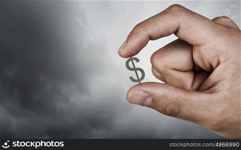 Money symbol between fingers. Tiny dollar currency sign holden between fingers
