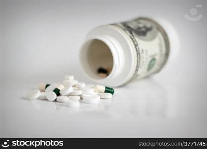Money with pills, high costs of expensive medication concept. Shallow depth of field.
