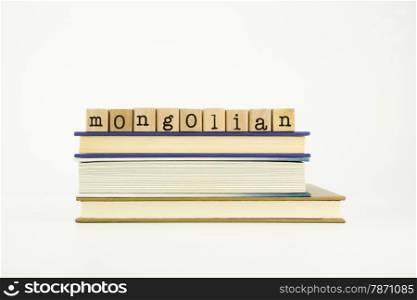 mongolian word on wood stamps stack on books, language and education concept