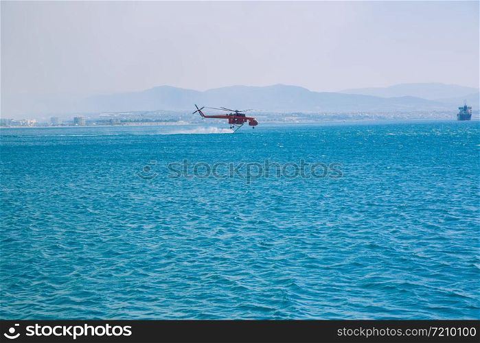Moni Osiou Patapiou, Greek Republic. The helicopter fills with water to extinguish the fire. 14. Sep. 2019