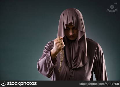 Monk in religious concept on gray background