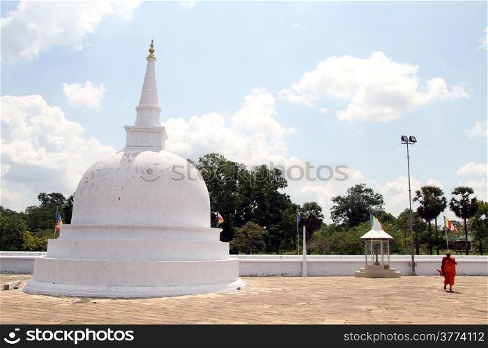 Monk walk near white stupa in Anuradhapura, Sri Lanka