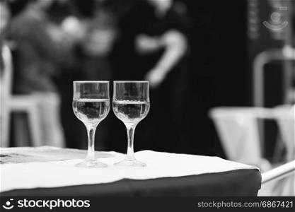 Monochrome image of glass of wine at the street cafe table