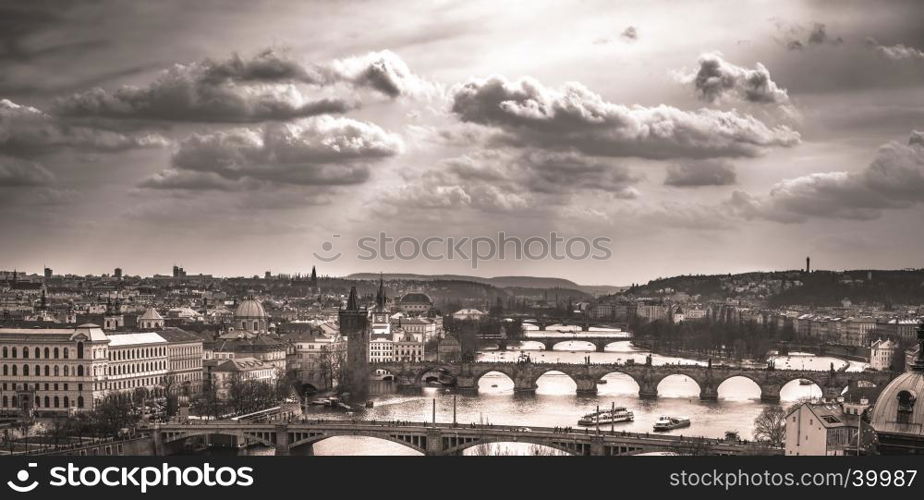 Monochrome image with the old center of Prague, the capital of Czech Republic, with its antique bridges and historical buildings, under a dramatic sky.