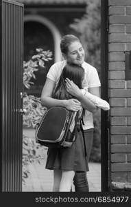 Monochrome photo of happy mother and daughter meeting after school