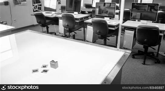 Monochrome representation of a college graphic design classroom with light table and slides