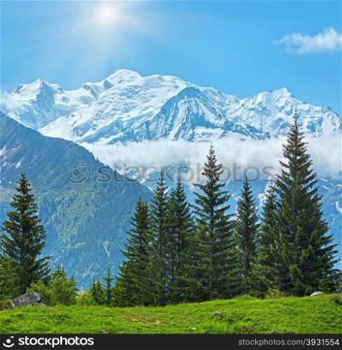 Mont Blanc mountain massif with sunshine in blue sky (Chamonix valley, France, view from Plaine Joux outskirts).