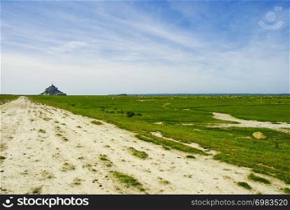 Mont Saint Michel with sheep on blue sky