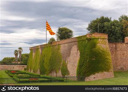 Montjuic hill in Barcelona, Catalonia, Spain. Flag of Catalonia over Montjuic Castle, old military fortress on top of Montjuic hill in Barcelona, Catalonia, Spain