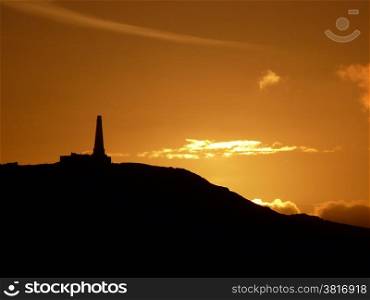 Monument at sunset. Old decaying hilltop monument in bright sunset